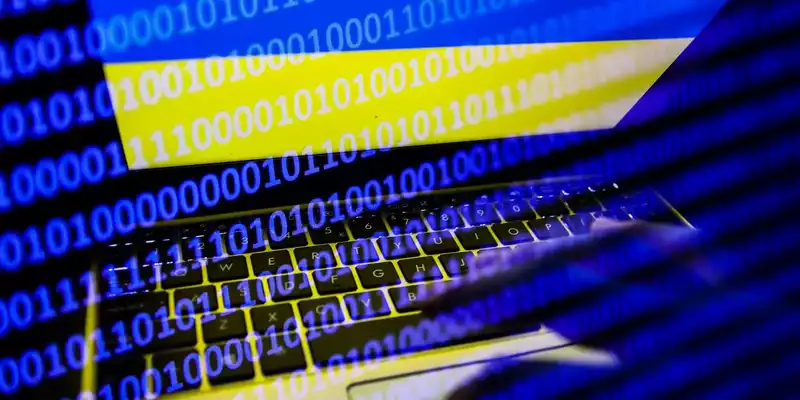 ukrainian flag displayed on a laptop screen and binary code code displayed on a screen are seen in this multiple exposure illustration photo taken in krakow poland on february 16 2022